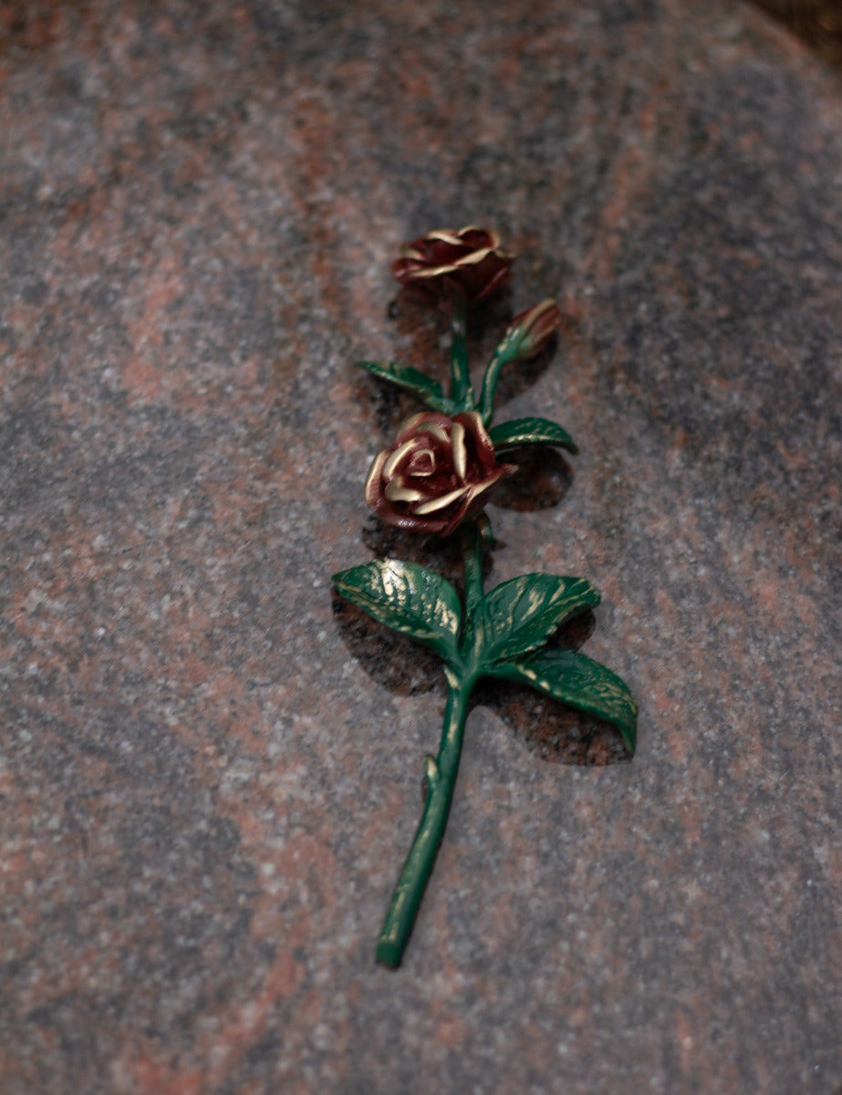 Rose Bronze grün mit roten Blüten